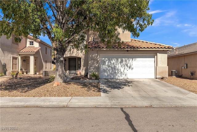 mediterranean / spanish home with cooling unit and a garage