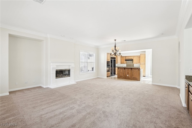 unfurnished living room with crown molding, a notable chandelier, and light colored carpet