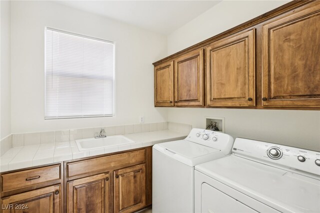 laundry room with sink, cabinets, and separate washer and dryer