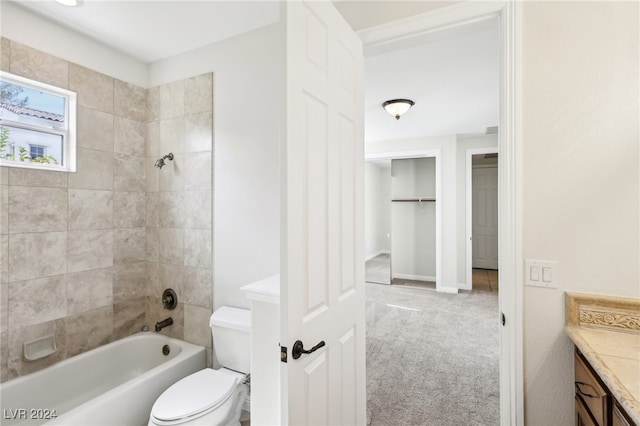 full bathroom featuring tiled shower / bath, vanity, and toilet