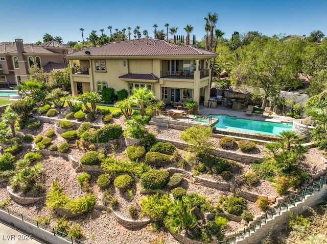 back of house with a patio, a fenced in pool, and a balcony