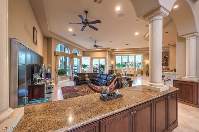 living room with decorative columns and ceiling fan