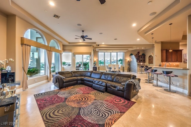 living room featuring sink, a healthy amount of sunlight, light tile patterned floors, and ceiling fan