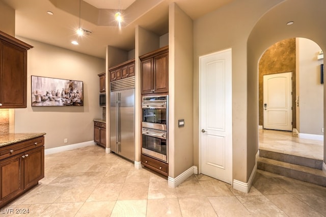 kitchen with light stone countertops and appliances with stainless steel finishes