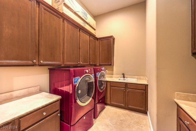 washroom featuring cabinets, sink, and washing machine and clothes dryer