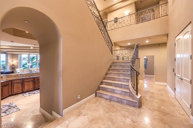 stairway with sink and a high ceiling