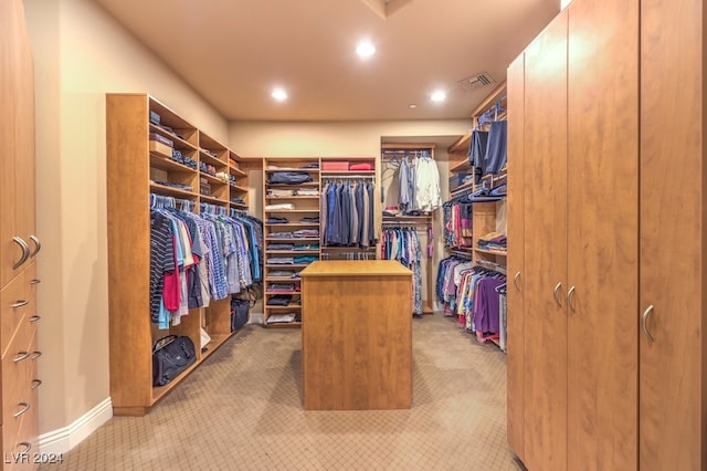 spacious closet featuring light colored carpet