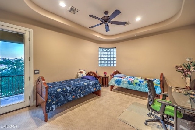 carpeted bedroom featuring access to outside, a raised ceiling, and ceiling fan