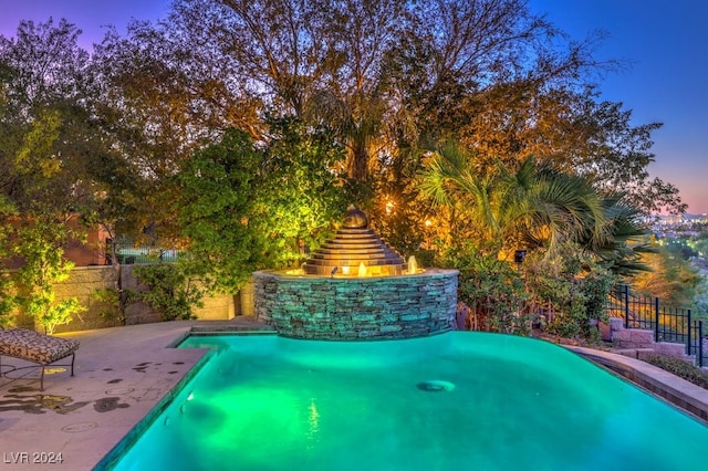 pool at dusk featuring a patio