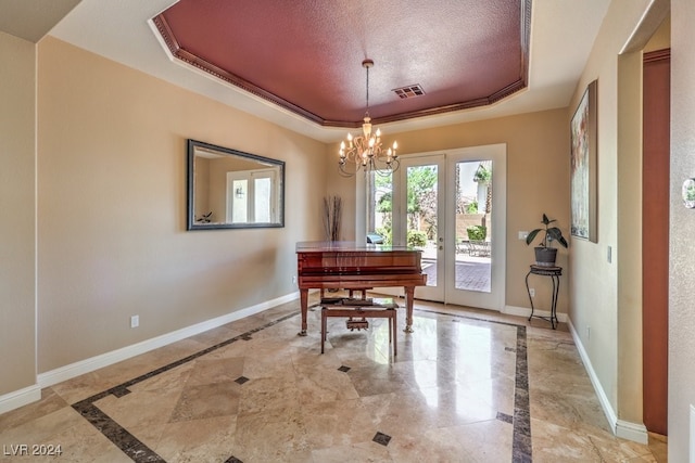 misc room featuring a notable chandelier, a tray ceiling, crown molding, and a textured ceiling