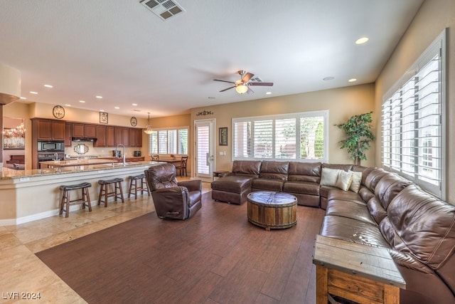 living room featuring sink, hardwood / wood-style flooring, and ceiling fan