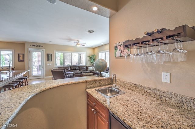 kitchen featuring ceiling fan, a textured ceiling, sink, and a wealth of natural light