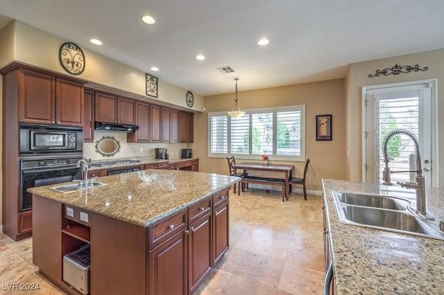 kitchen with a center island with sink, pendant lighting, black appliances, and sink