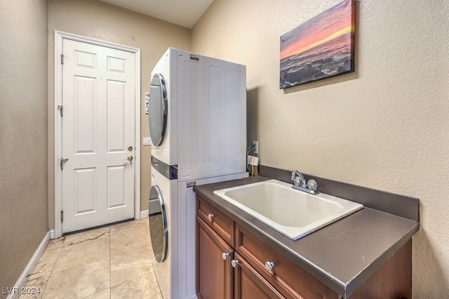 laundry room featuring cabinets, light tile patterned floors, sink, and stacked washer / drying machine