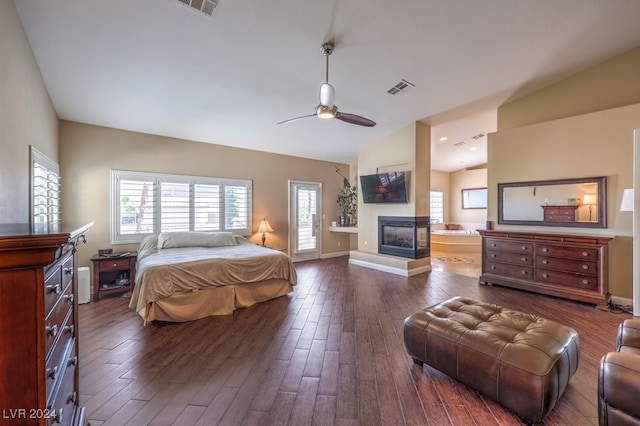 bedroom with a multi sided fireplace, vaulted ceiling, dark hardwood / wood-style flooring, and ceiling fan