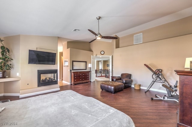 bedroom featuring lofted ceiling, a multi sided fireplace, dark hardwood / wood-style flooring, and ceiling fan