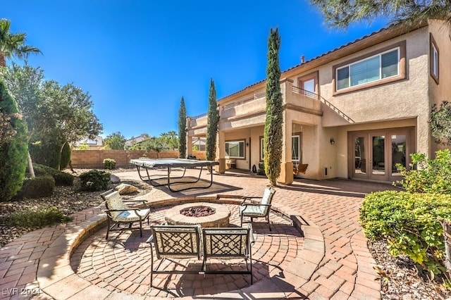 back of property featuring a fire pit and a patio area