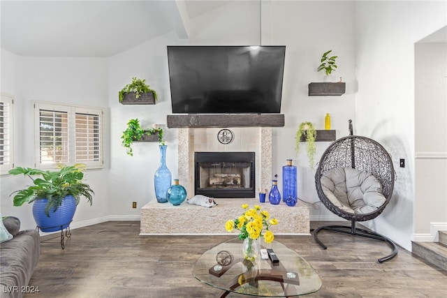 living room featuring lofted ceiling with beams, a fireplace, and wood-type flooring