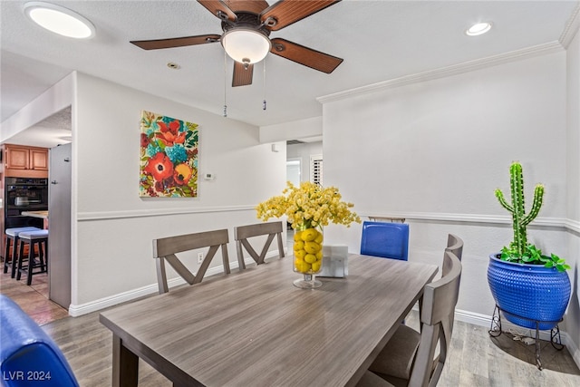 dining space featuring ceiling fan, hardwood / wood-style flooring, and crown molding