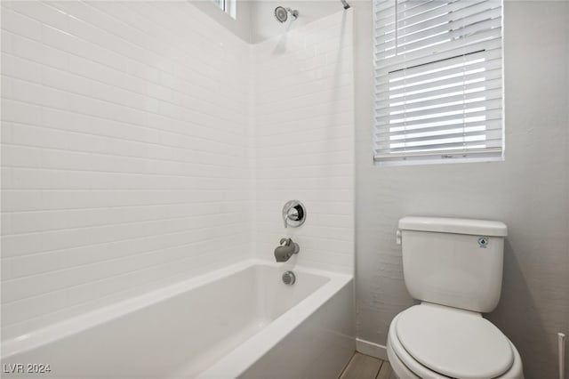 bathroom featuring shower / bath combination, toilet, and a wealth of natural light