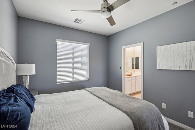 bedroom with ceiling fan, connected bathroom, and carpet flooring