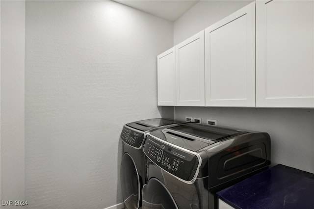 laundry area with washer and clothes dryer and cabinets