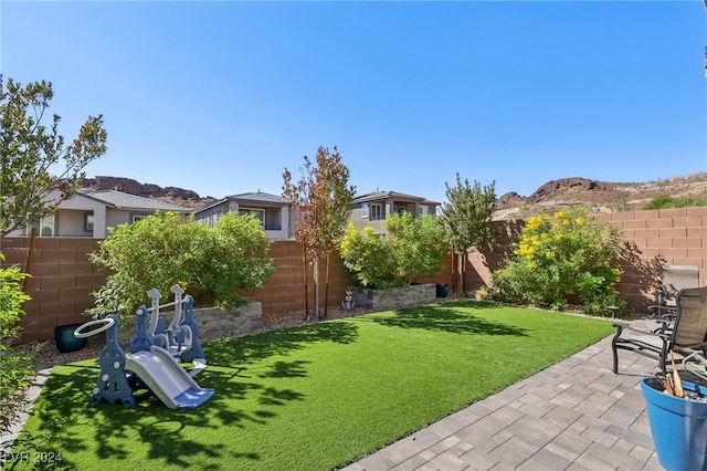 view of yard featuring a playground and a patio area