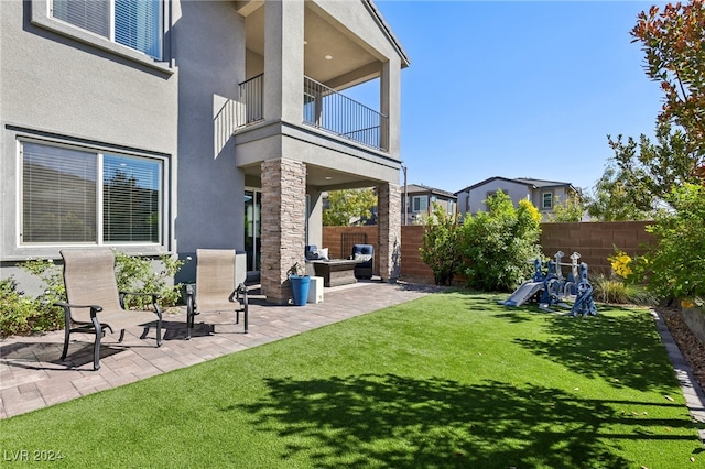 view of yard with a balcony and a patio