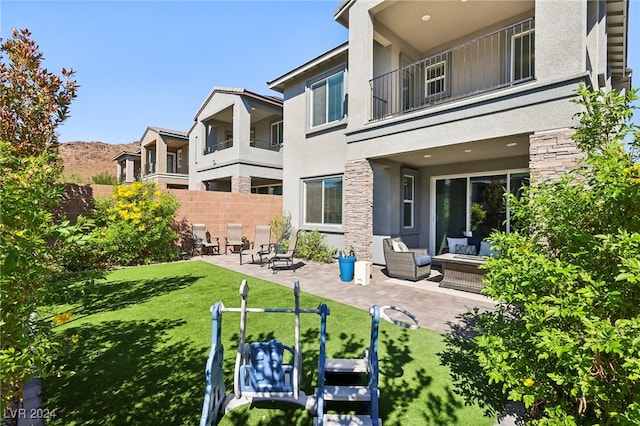 exterior space featuring a lawn, an outdoor hangout area, a balcony, and a patio area