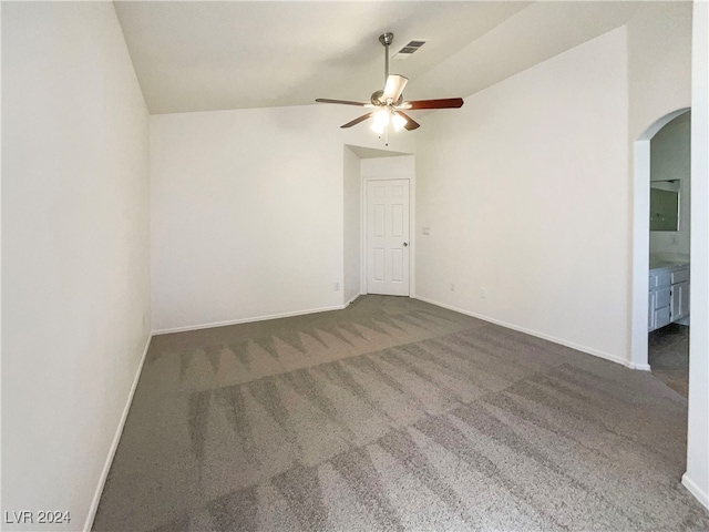 unfurnished room featuring ceiling fan, vaulted ceiling, and dark colored carpet