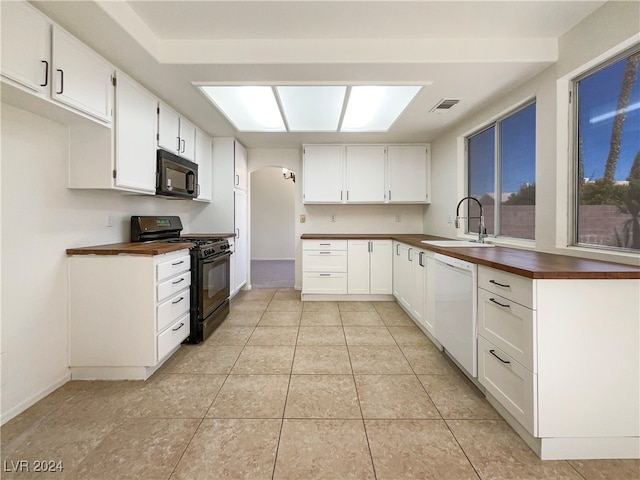 kitchen featuring black appliances, white cabinetry, sink, and light tile patterned floors