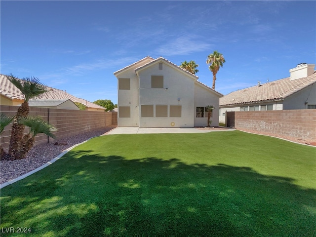 rear view of house featuring a yard and a patio area