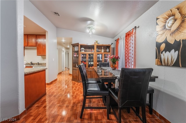 dining room featuring hardwood / wood-style flooring, ceiling fan, and vaulted ceiling