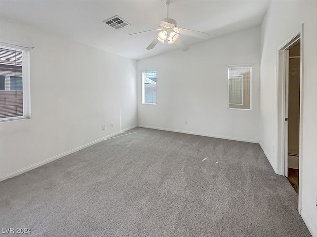 empty room with ceiling fan, lofted ceiling, and carpet flooring