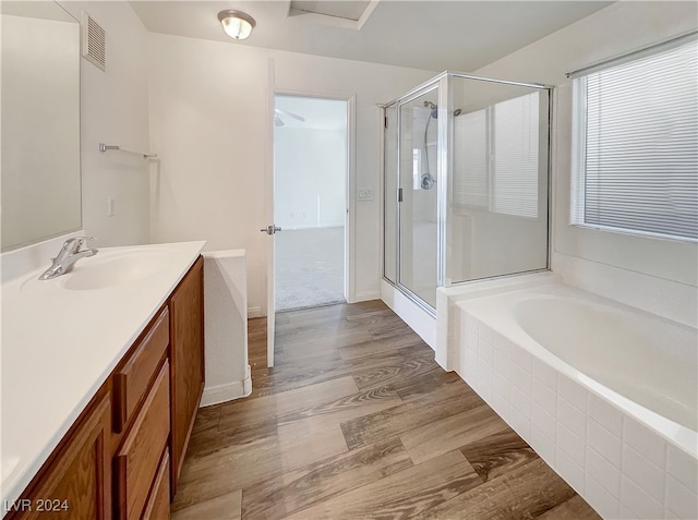 bathroom featuring hardwood / wood-style floors, vanity, and separate shower and tub