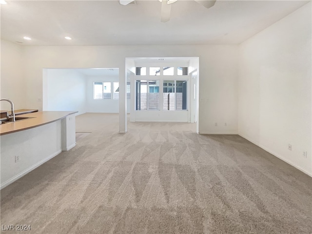 carpeted empty room with ceiling fan and sink