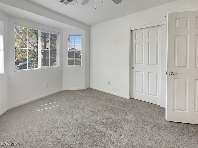 unfurnished bedroom with a closet, ceiling fan, and carpet floors