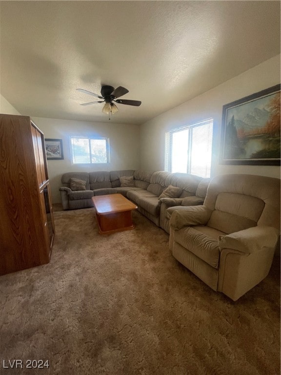 living room with ceiling fan, carpet floors, and a textured ceiling