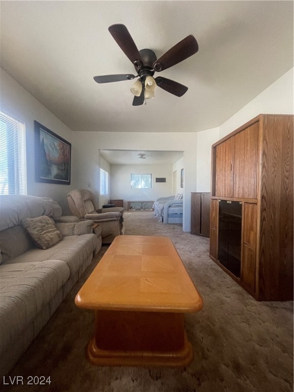 living room with ceiling fan, plenty of natural light, and carpet flooring