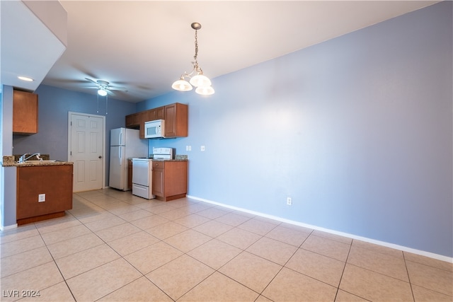 kitchen with ceiling fan with notable chandelier, white appliances, pendant lighting, and light tile patterned floors