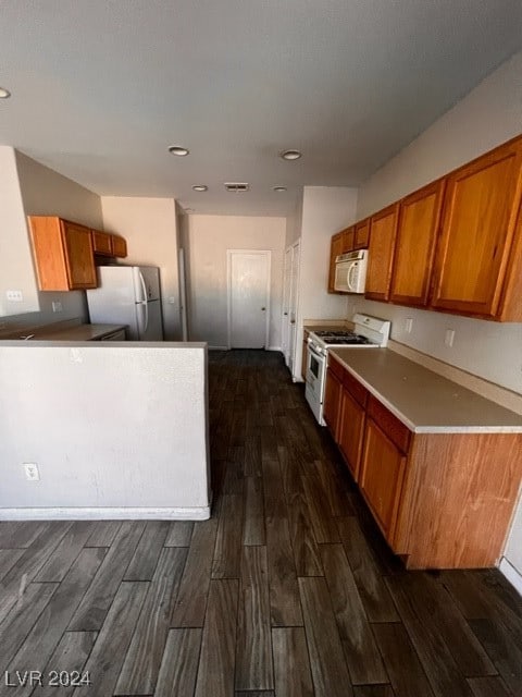 kitchen featuring white appliances and dark wood-type flooring