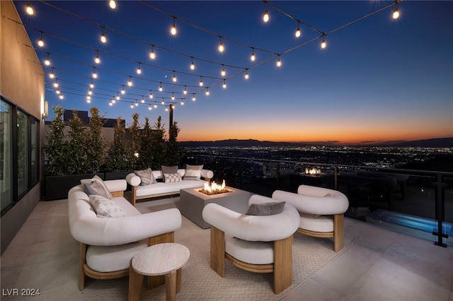 patio terrace at dusk with an outdoor living space with a fire pit