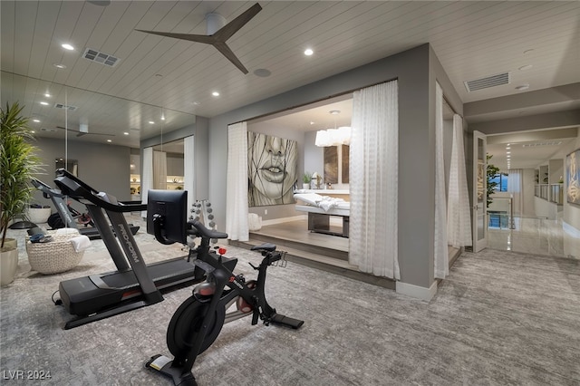 workout area with ceiling fan, carpet floors, and wooden ceiling