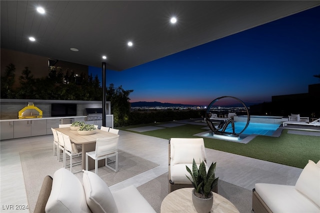 patio terrace at dusk with grilling area and an outdoor hangout area