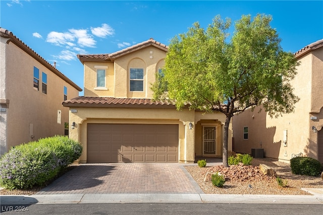 mediterranean / spanish-style home featuring cooling unit and a garage