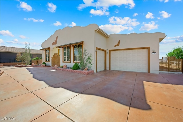 pueblo-style house featuring a garage