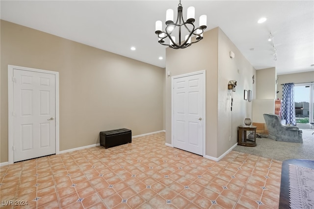 unfurnished dining area with an inviting chandelier and track lighting