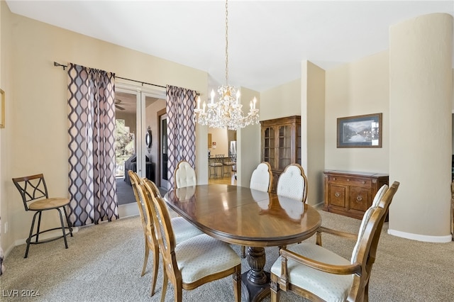 dining room with light colored carpet and a chandelier