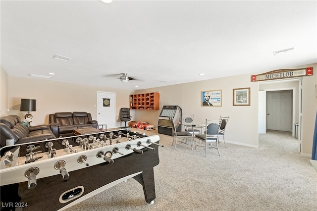 recreation room with ceiling fan and light colored carpet