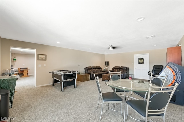 carpeted dining room with ceiling fan